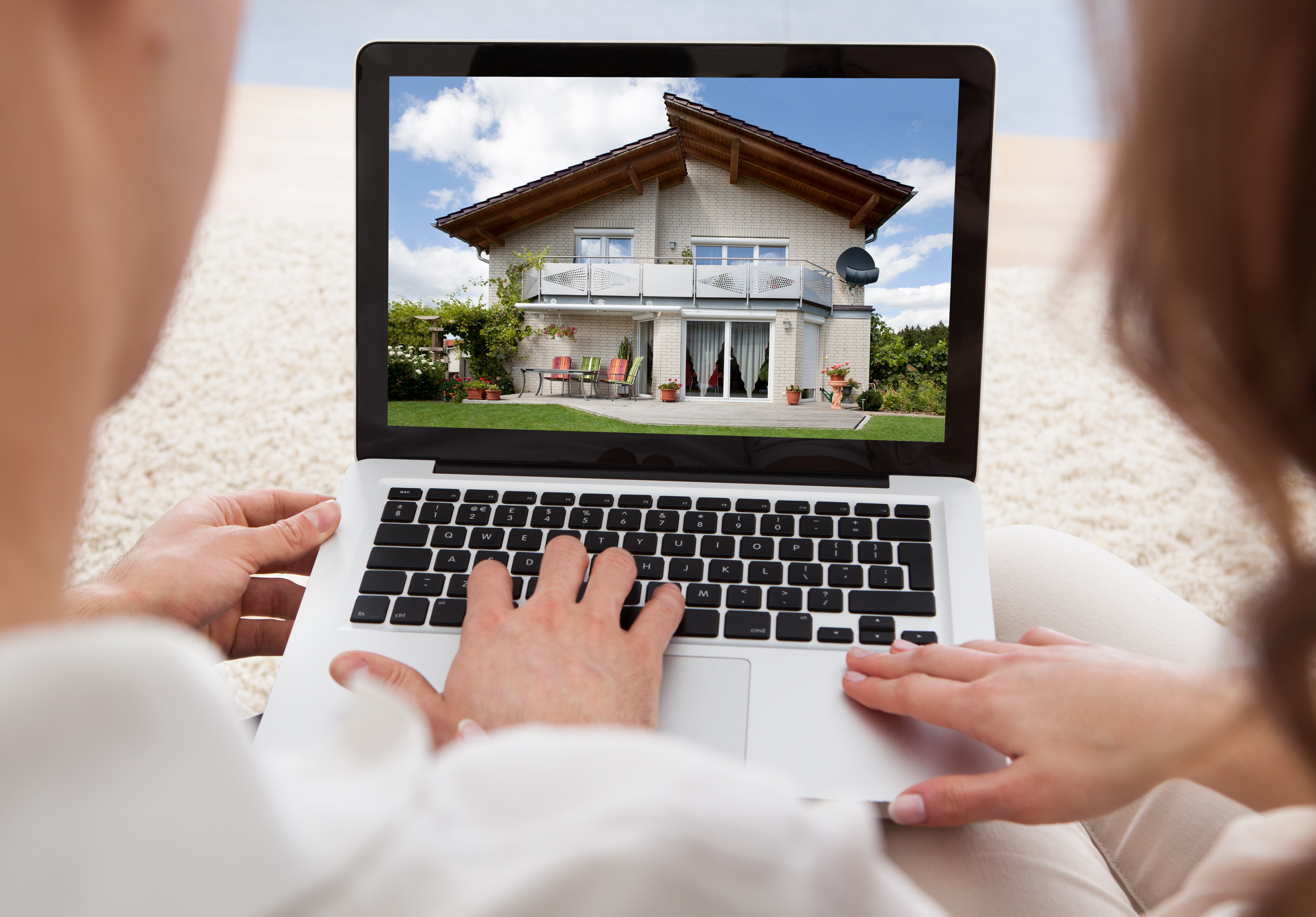 Couple Looking At House On Laptop's Screen